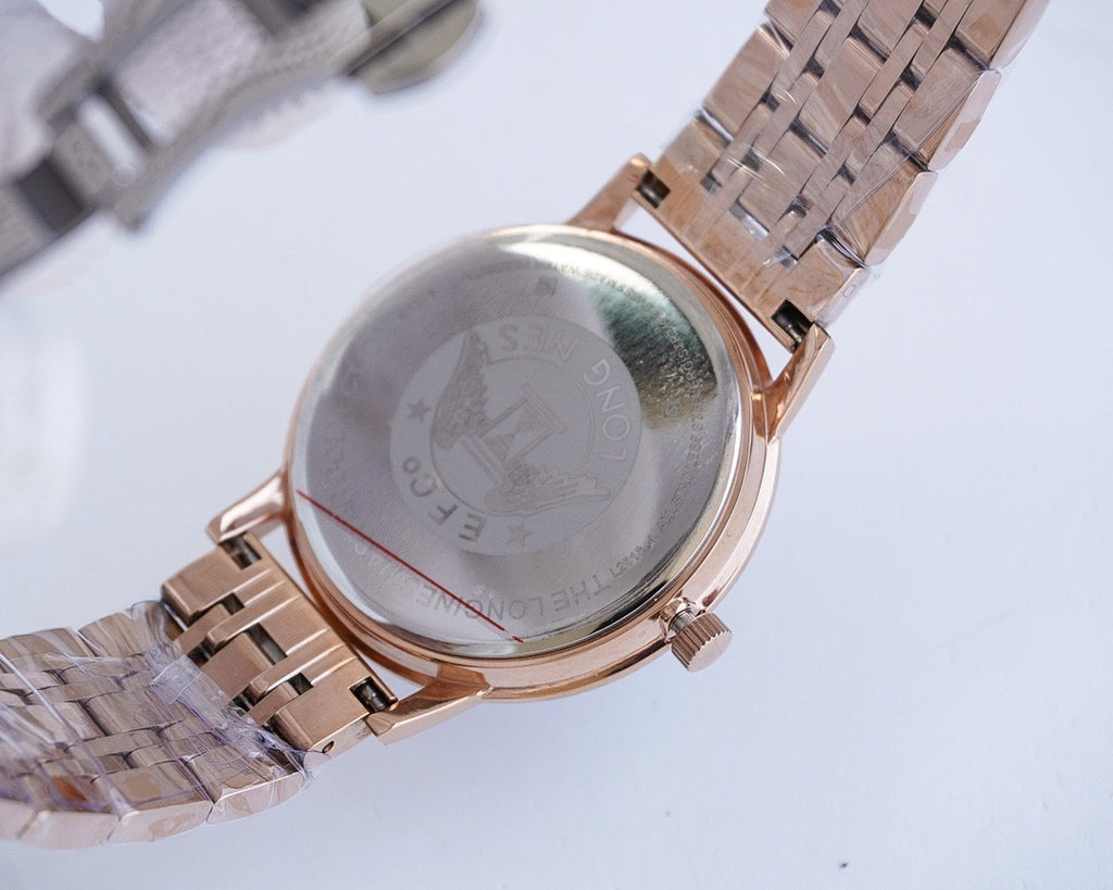 Two-tone wristwatch caseback on metal strap, rose-gold tone with engraved back