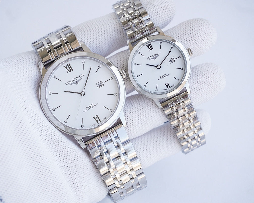 Two-tone wristwatch pair with silver dials, Roman numerals, and metal link bracelets