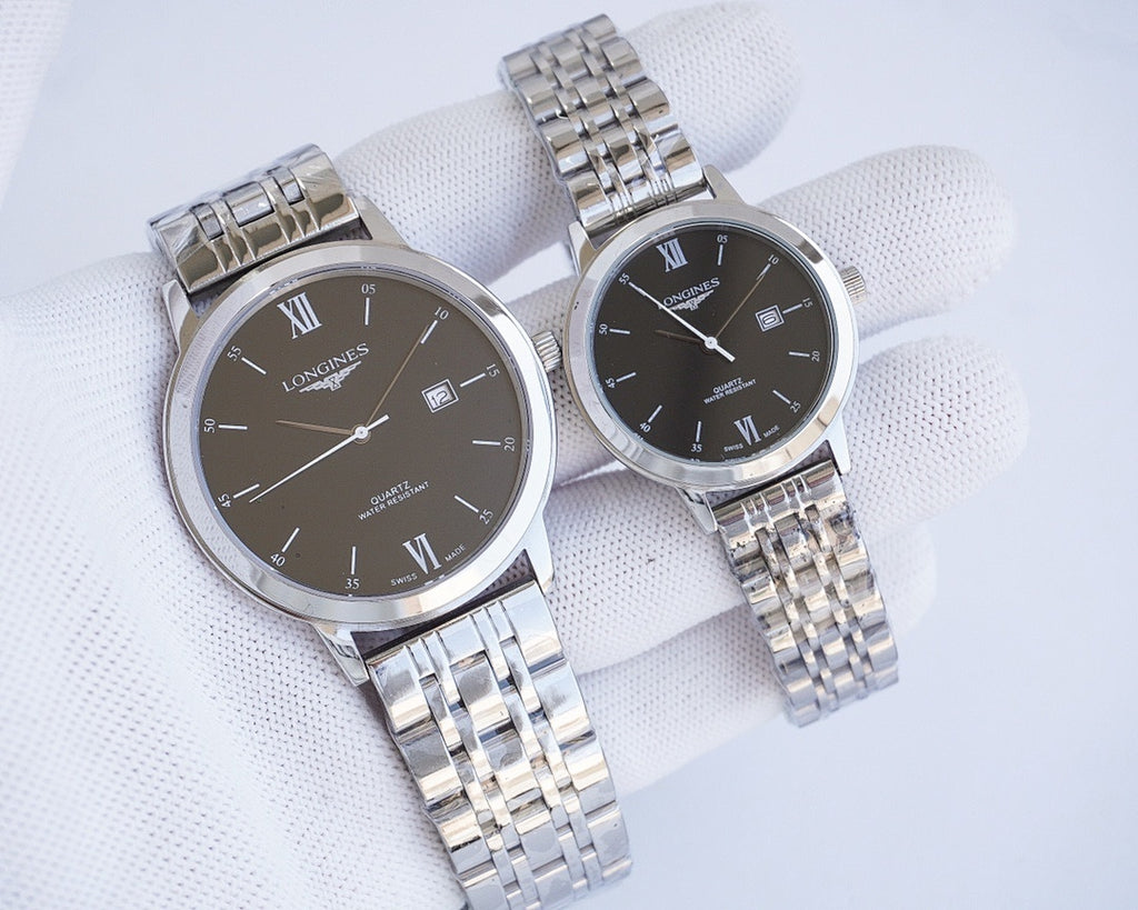 Two-tone wristwatch pair with black dials, Roman numerals, and metal link bracelets