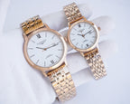 Gold-tone two-tone wristwatch pair with white dials and Roman numerals on metal links
