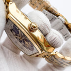 Longines watch case close-up with gold-tone bezel and see-through skeleton dial.