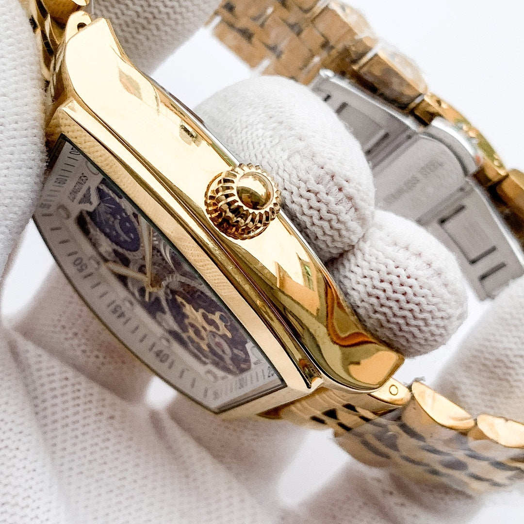 Longines watch case close-up with gold-tone bezel and see-through skeleton dial.