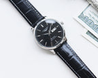 Longines watch with black dial and dark leather strap, round case with crown