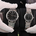 Longines quartz wristwatch with black dial and silver-tone metal bracelet, Roman numerals