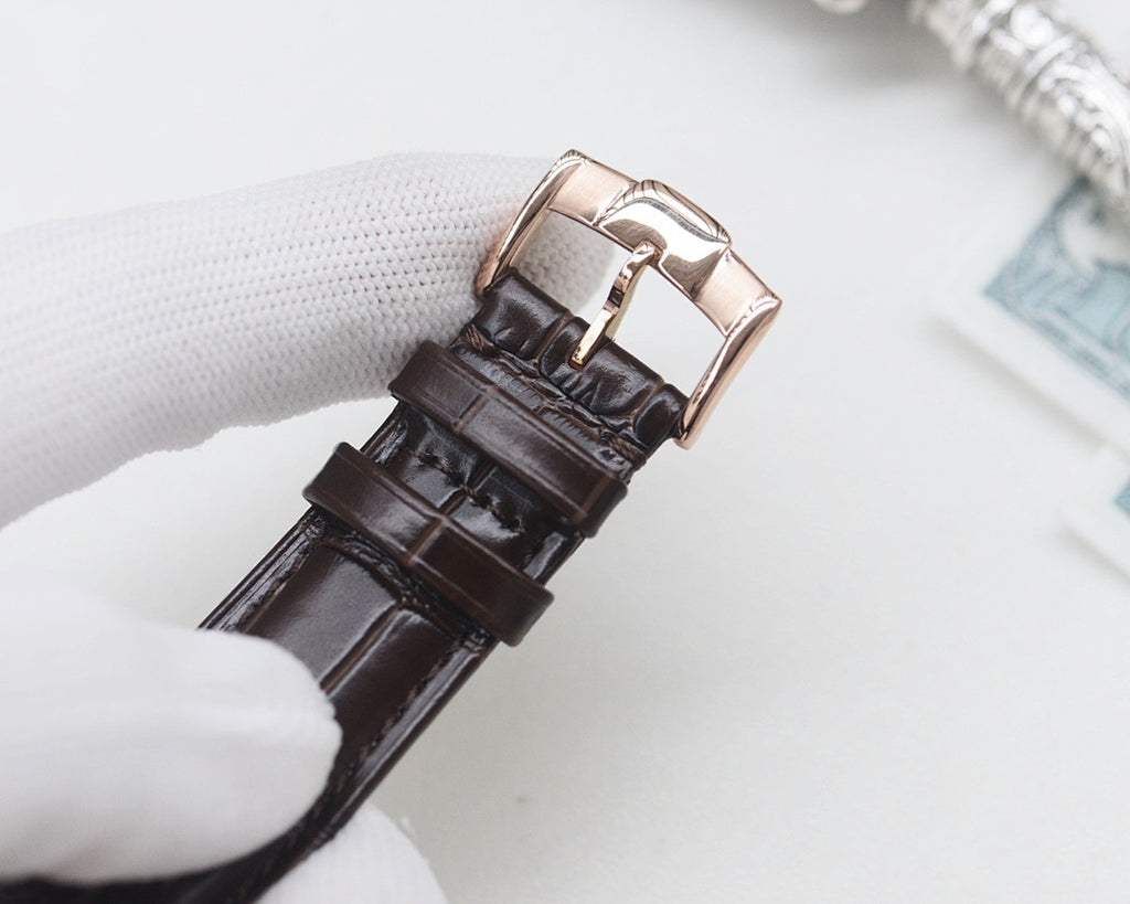 Black leather watch strap with rose gold buckle clasp and pin, metal keeper