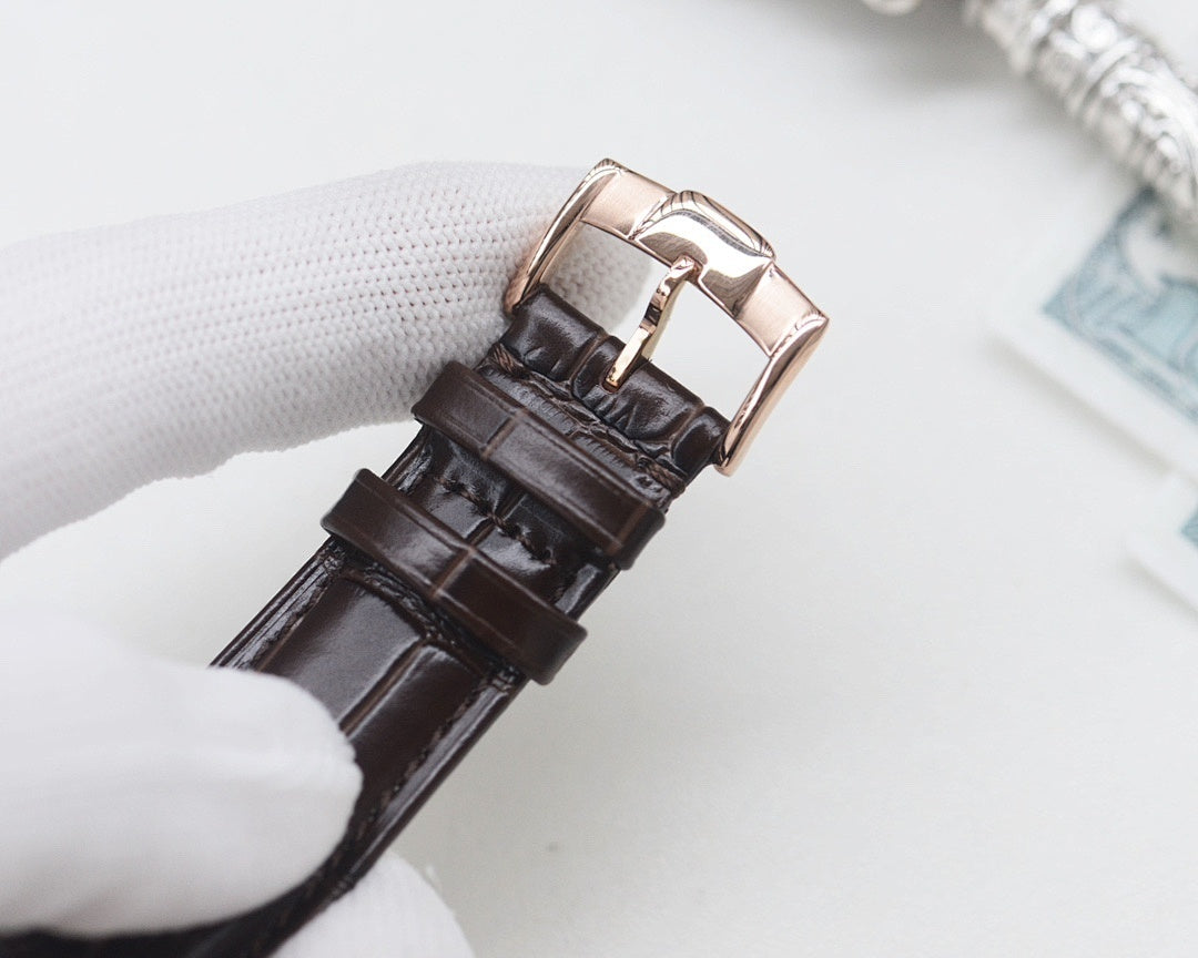 Black leather watch strap with rose gold buckle clasp and pin, metal keeper