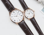 Two white-dial quartz watches, Roman numerals, rose gold cases, dark leather straps