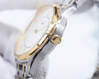 Two-tone Longines watch side view with crown detail and silver-and-gold case.