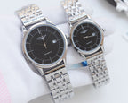 Pair of quartz wristwatches with black dials and silver metal bracelet straps