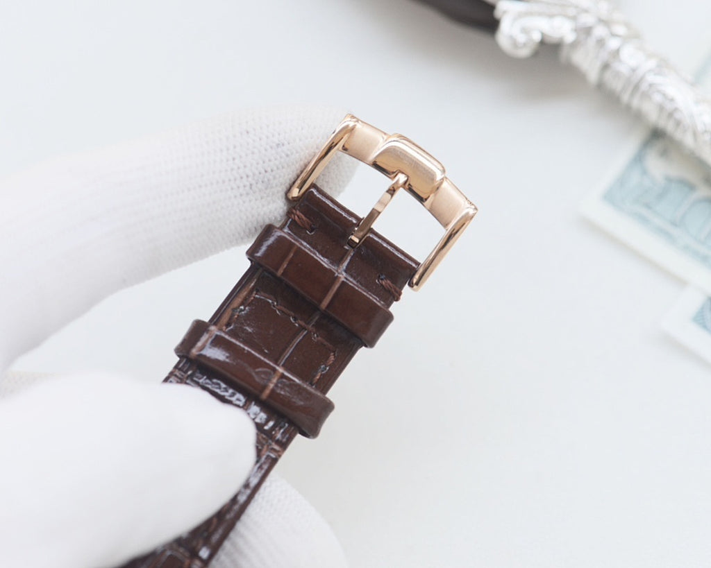 Brown leather watch strap with gold-tone buckle and clasp hardware