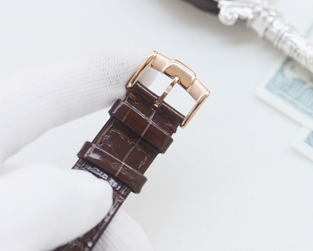 Brown leather watch strap with gold-tone buckle and clasp hardware
