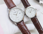 Pair of quartz wristwatches with white dials and brown leather strap
