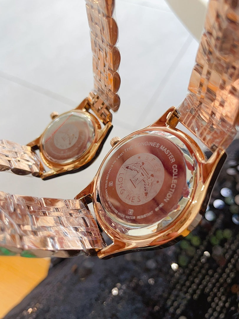 Longines watch pair close-up of gold-tone case backs with engraved details
