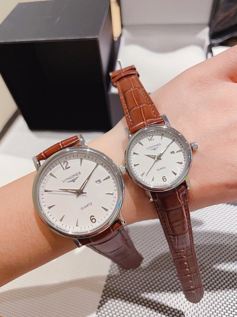 Leather-banded watch with white dial, brown strap; round silver-tone case.