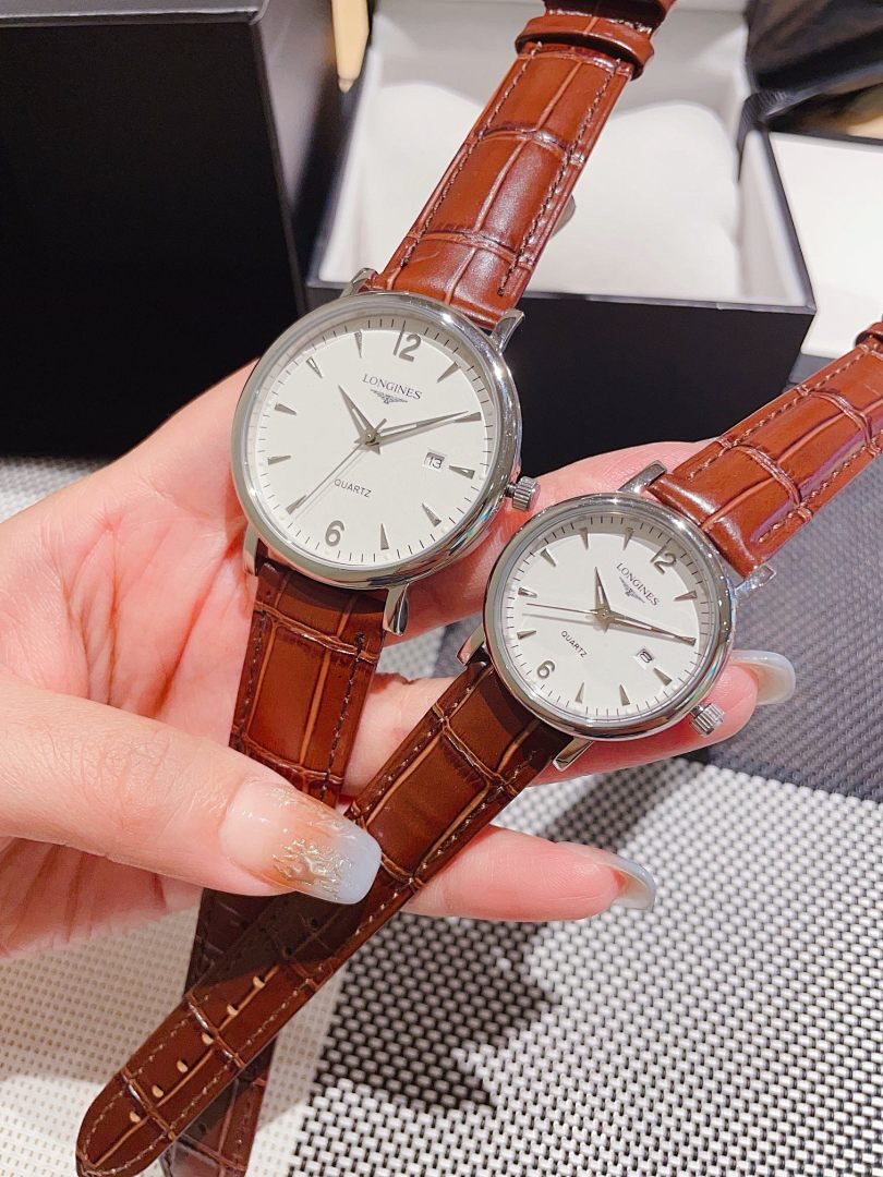 Leather-banded watch with white dial, brown strap; two round silver-tone cases.