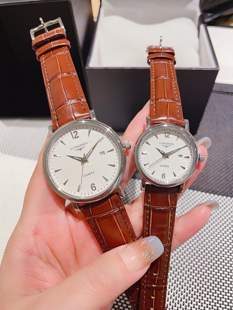 Leather-banded watch with white dial, brown strap; round silver-tone cases.