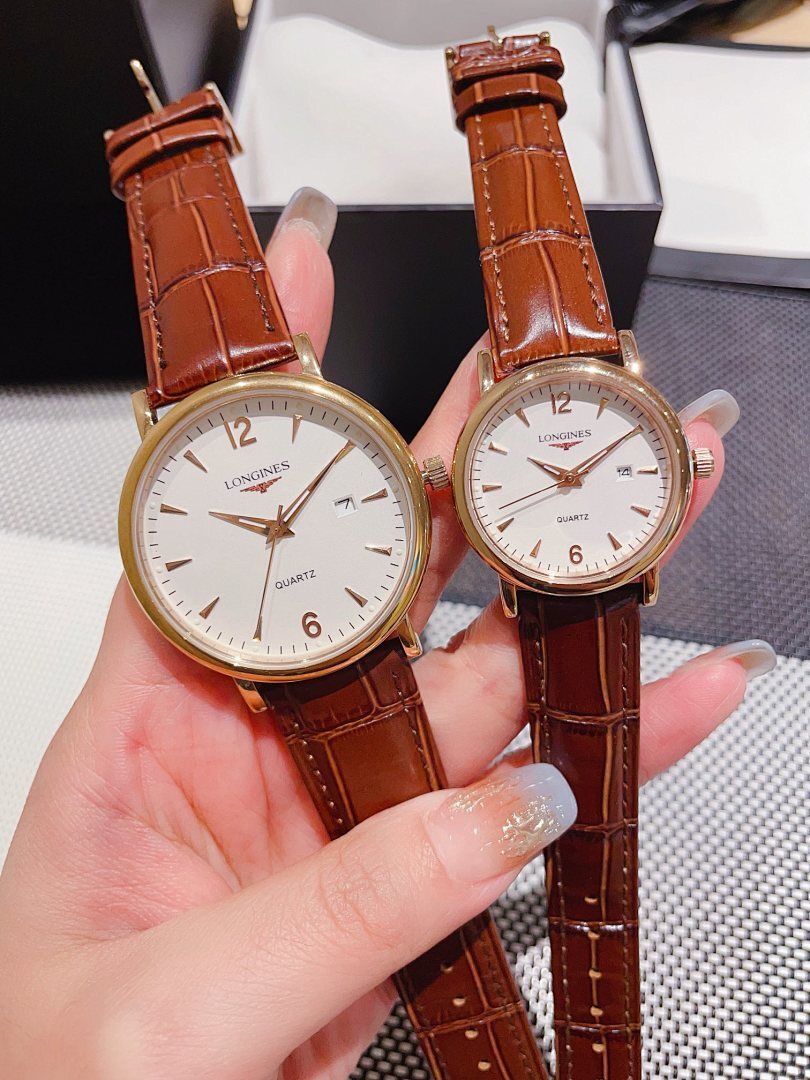 Leather-banded watch with white dial, brown strap; round gold-tone case.