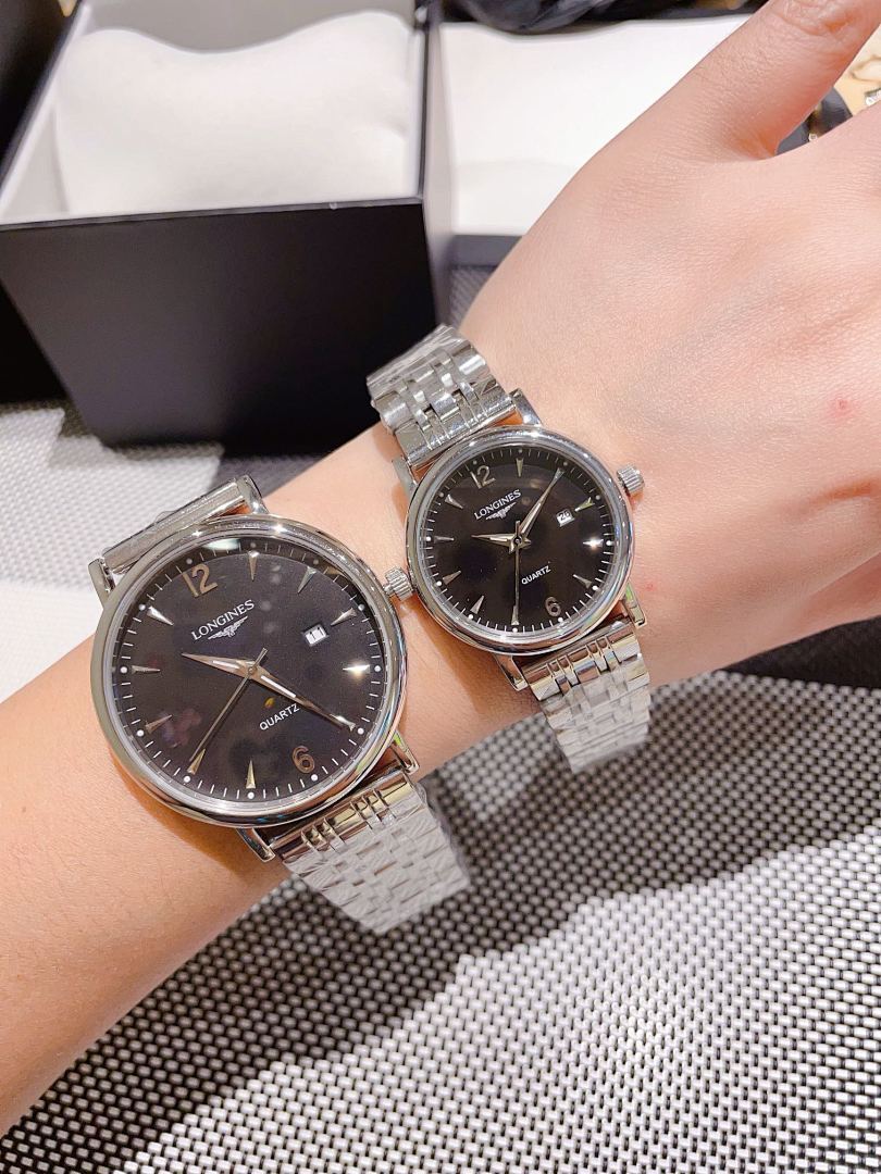 Pair of Longines stainless steel watches with dark dials, metal link bracelets
