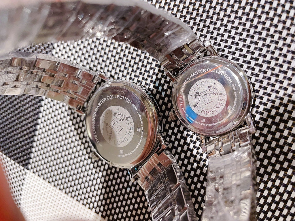 Back view of two Longines watches on metal link bracelets, casebacks visible