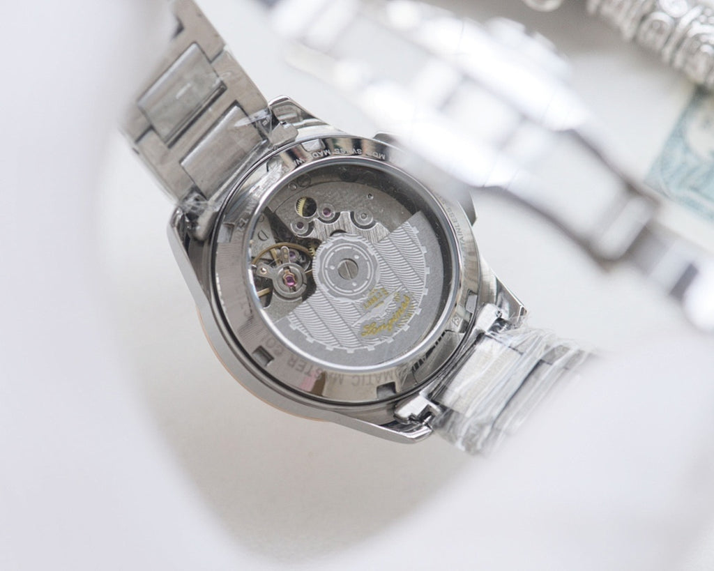 Longines watch open caseback showing mechanical movement, silver stainless bracelet