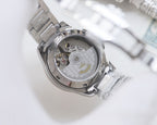 Longines watch open caseback showing mechanical movement, silver stainless bracelet