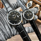 Pair of Longines quartz watches with black dials and black leather straps
