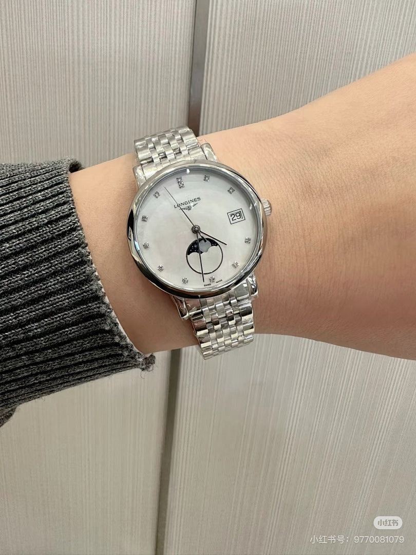 Longines wristwatch on a wrist, silver metal bracelet and white dial with moon-phase subdial