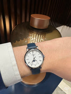 Longines wristwatch on a wrist, blue leather strap, silver case, white dial