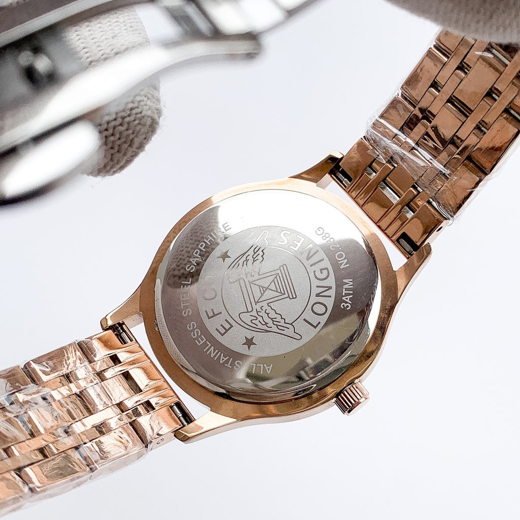 Longines watch case back on rose-gold metal bracelet, engraved emblem and text