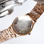 Longines watch case back on rose-gold metal bracelet, engraved emblem and text