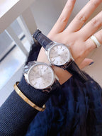 Two Longines wristwatches with dark leather straps and light dials, worn on wrist