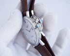 Longines watch with silver case and brown leather strap, side crown detail