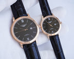 Longines watch pair with dark dial, rose-gold cases, and black leather straps