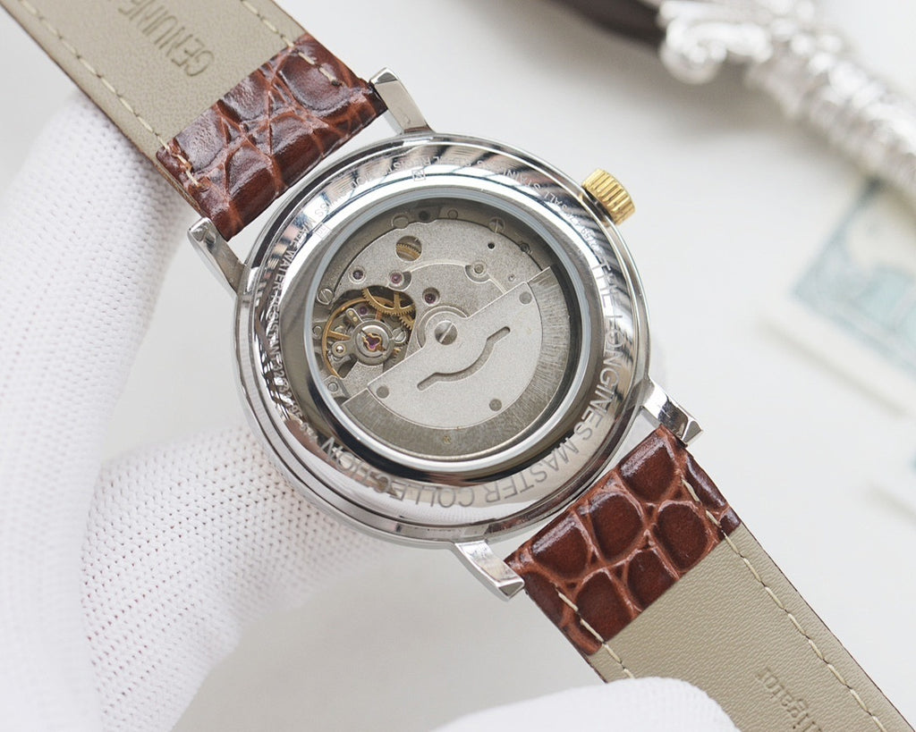 Brown leather strap wristwatch with round steel caseback and visible inner mechanism