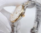 Longines watch crown side on two-tone case with white dial under glove
