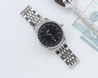Longines watch with black dial and Roman numerals, stainless steel bracelet