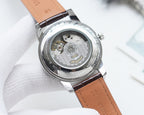 Longines watch with open caseback showing movement, leather strap with brown finish