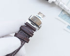 Longines wristwatch showing clasp and dark brown leather strap with stitched edges