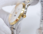 Wristwatch side profile with gold crown on silver case.