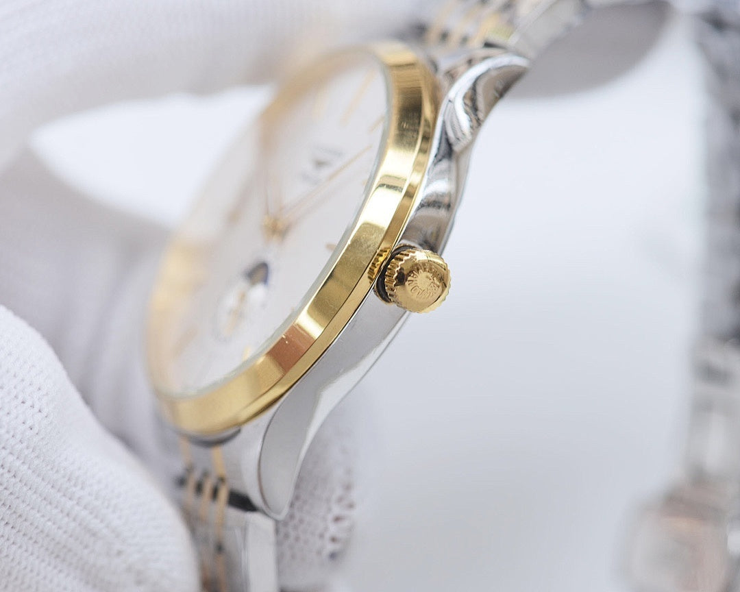 Wristwatch side profile with gold crown on silver case.