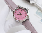 Round wristwatch with pink dial and lavender leather strap, silver bezel