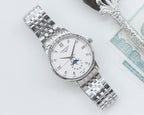 Longines watch with white dial, blue moonphase subdial, and stainless steel link bracelet