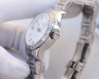 Wristwatch with white dial, stone-studded bezel detail, silver link bracelet.