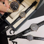 Longines watch with dark dial and black leather strap, shown held in hand.
