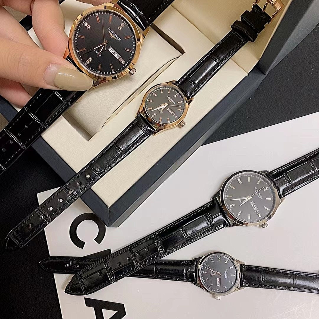 Longines watch with dark dial and black leather strap, shown held in hand.