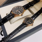Longines watch with dark dial and black leather strap, gold-tone bezel, in box.