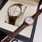 Longines watch with gold-tone case, white dial, brown leather strap.