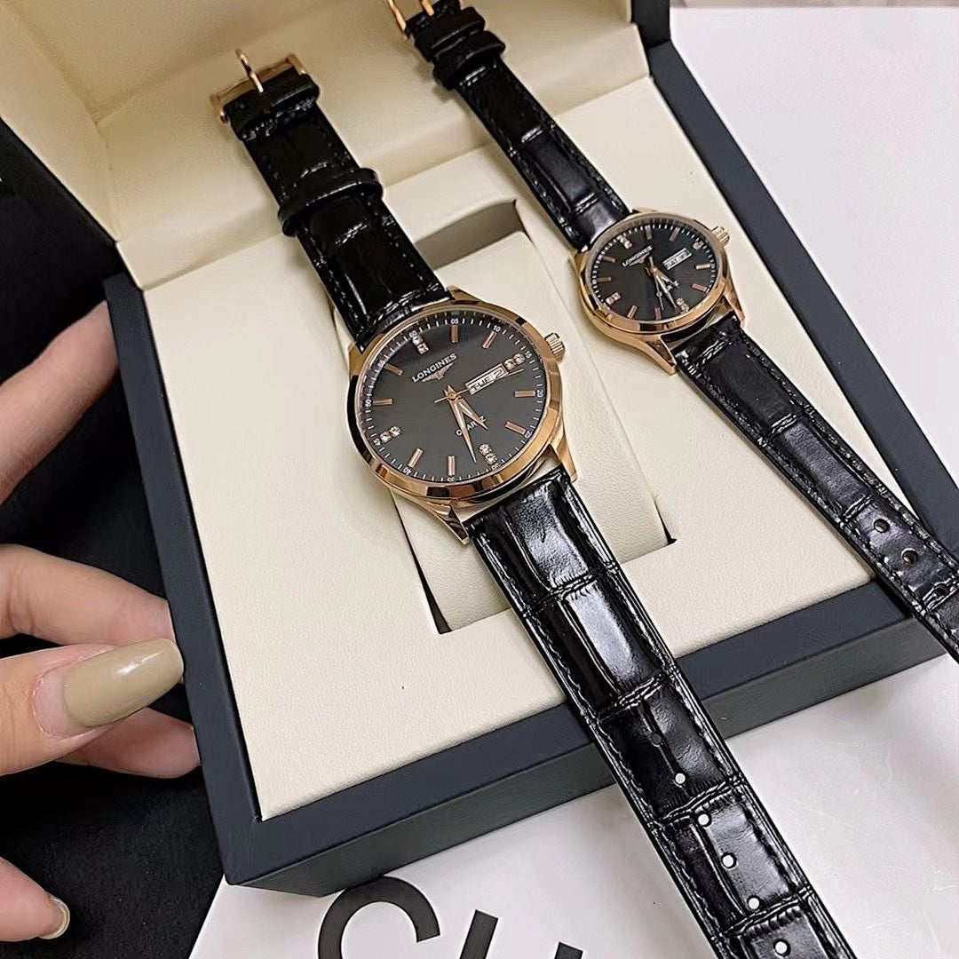 Longines watch with dark dial and black leather strap, shown in hand over box.