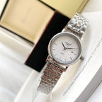 Longines watch with white dial and silver metal link bracelet on a wrist.