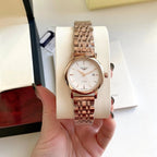 Longines watch with white dial and rose-gold metal link bracelet on display.